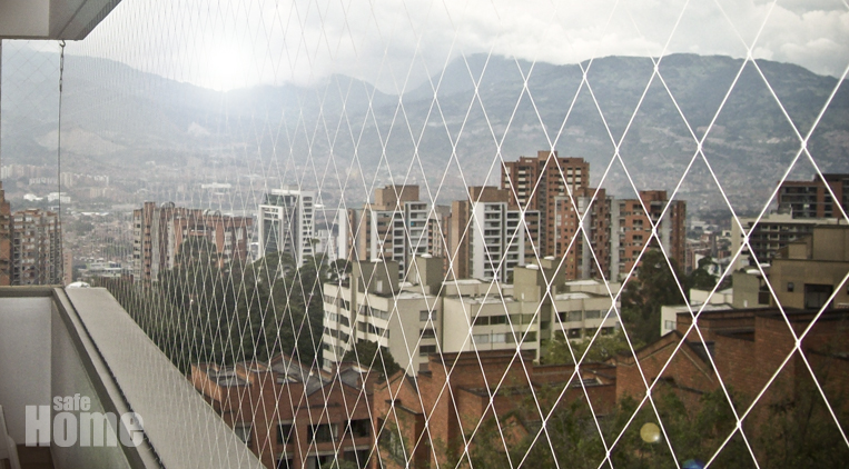 Malla de seguridad en balcón con vista a Medellín